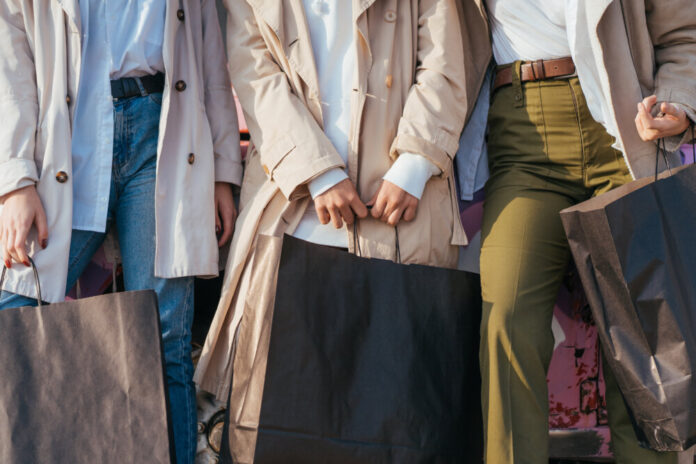 Young women posing near an old decorated car