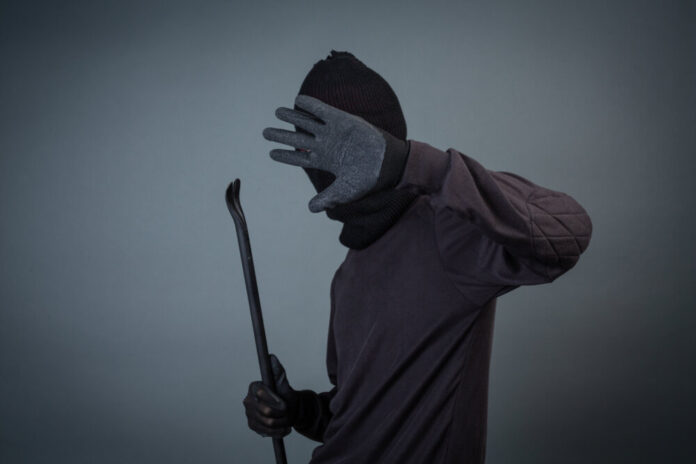 Black criminals wore a head yarn on a gray background.