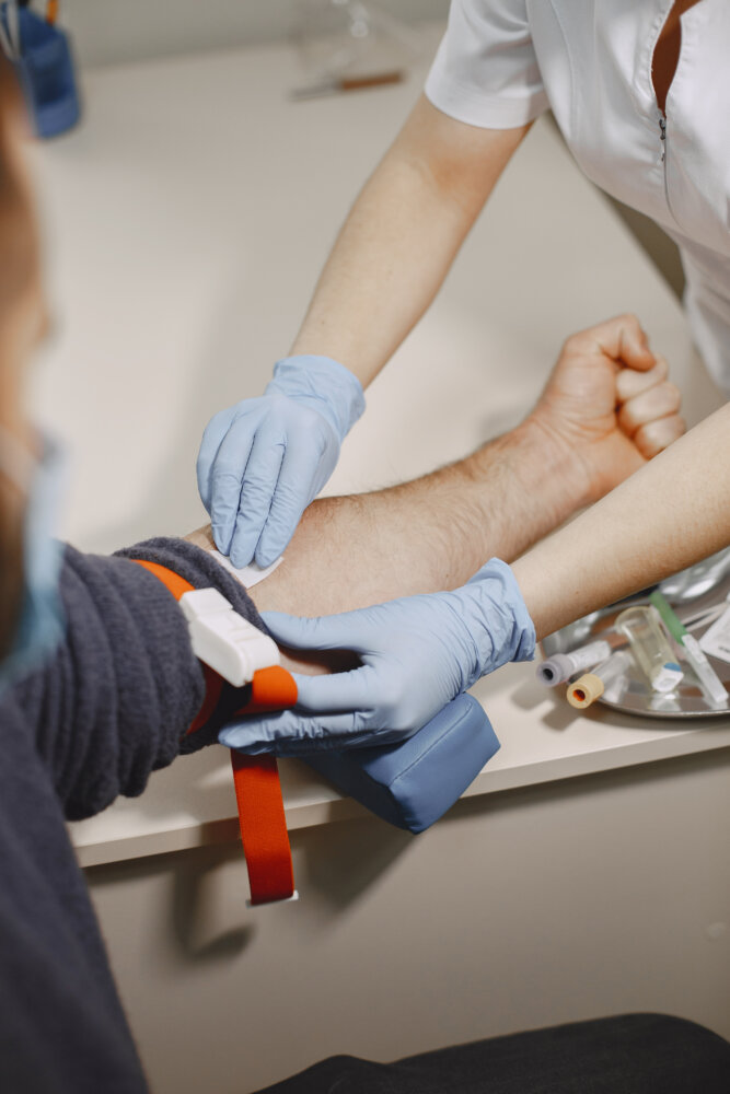 Nurse taking blood sample from patient at the doctors office