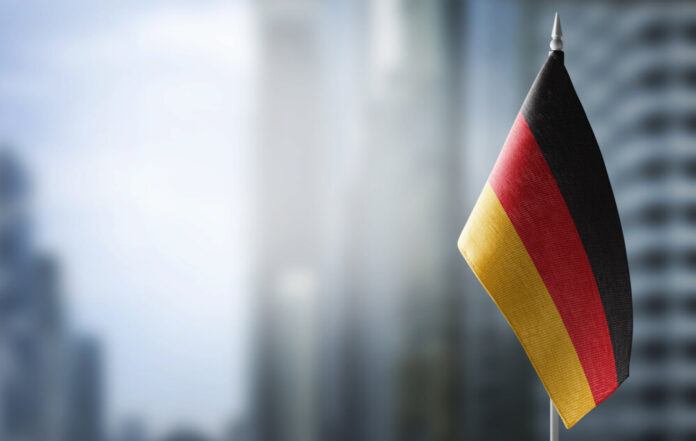 A small flag of Germany on the background of a blurred background
