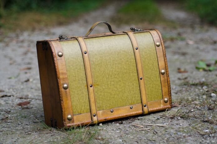 Selective focus shot of an old green suitcase with retro elements