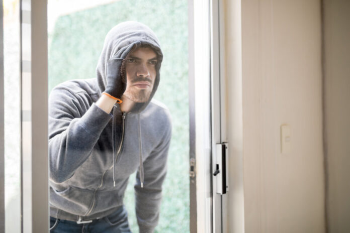 House robber looking inside a house
