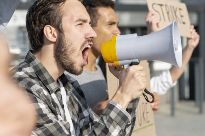 men-demonstrating-together-with-megaphone