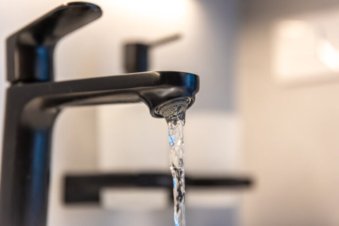 Black tap macro. Water flow. Minimal aesthetic