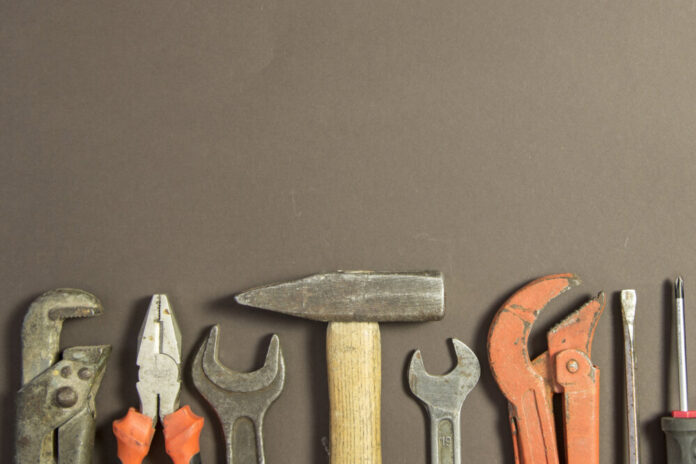 Construction tools on textured grunge paper consisting of pipe w