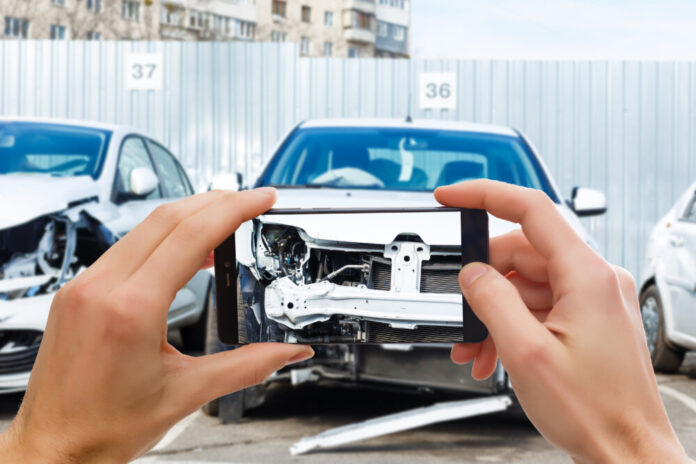 Man photographing his vehicle with damages for accident insurance with smart phone
