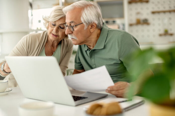 Senior couple analyzing their savings while going through home f
